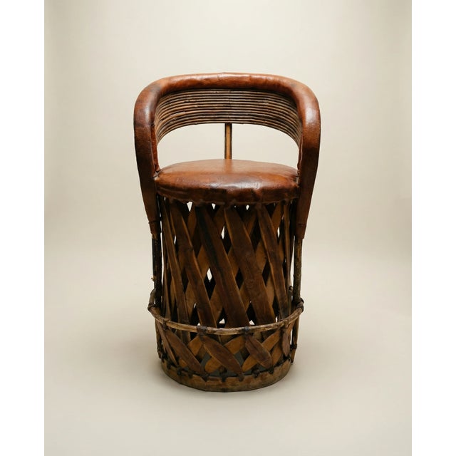 A beautifully handcrafted vintage Equipale chair, showcasing traditional Mexican craftsmanship with a sculptural barrel...