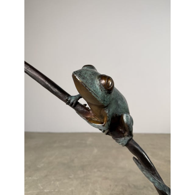 Beautifully hand cast bronze fountain sculpture of a frog perched along a branch. The whimsical frog figure is depicted...