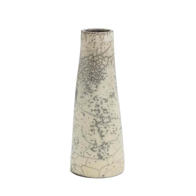 A Hana Vase, naturally colored, with a sleek surface that is elegantly graced with crackle' that emphasizes the harmonious...