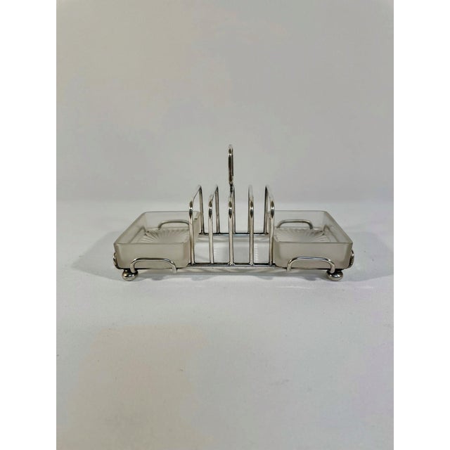 An elegant antique English Art Deco four slice Silverplated Toast Rack with the original rectangular frosted crystal...