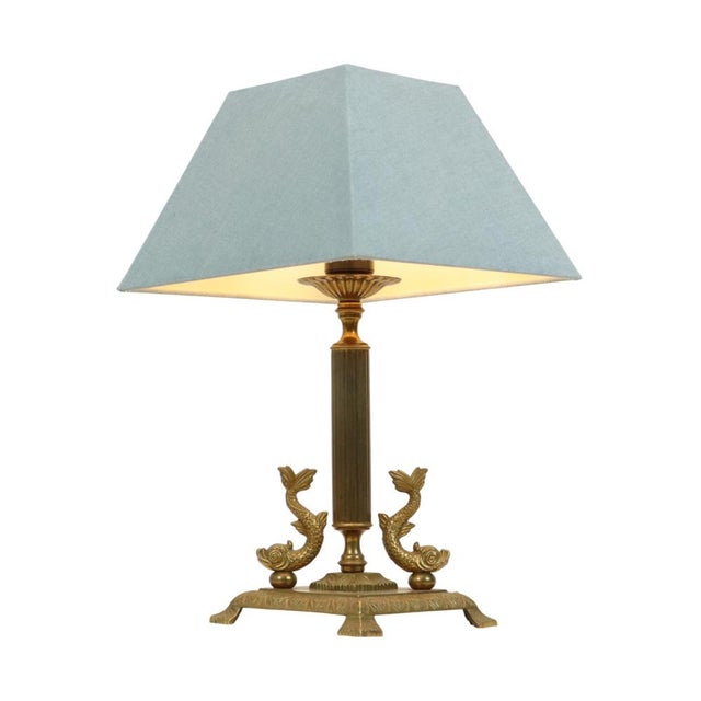 Classic vintage brass table lamp, a square brass base with a central column, along the sides two mythical fish or dolphins...