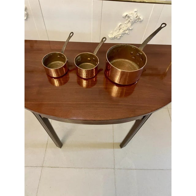 Three antique Victorian copper pans of circular form having a copper base, iron handles with copper rivets and hanging...