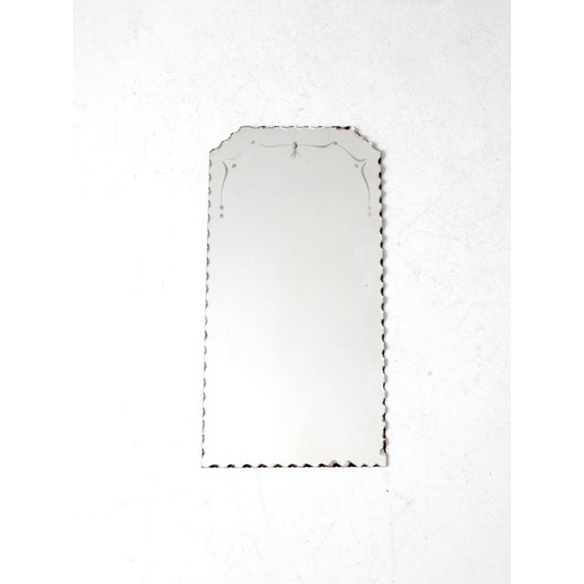 This vintage etched mirror exudes Art Deco elegance. Its scalloped edge, shaped top, and delicate etched white detailing...