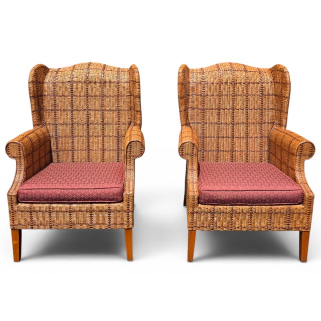 An exceptional pair of vintage Palecek lounge chairs showcasing a dramatic wingback silhouette executed entirely in...
