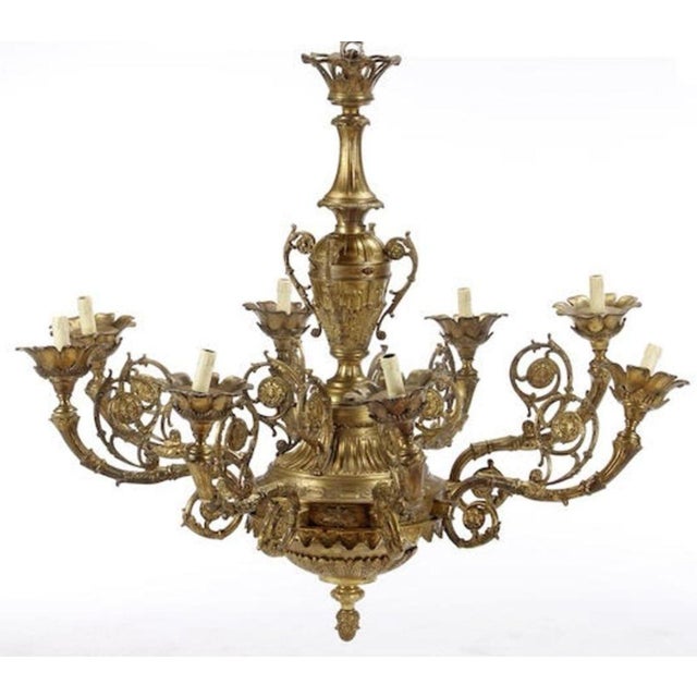 An elegant pair of English gilt bronze eight light chandeliers with beautiful botanical motif details all around the...