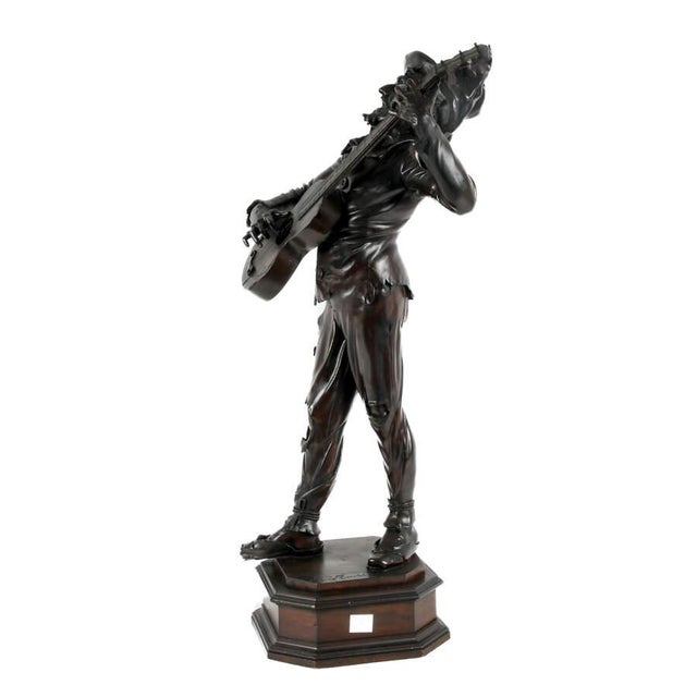 This antique carved wood sculpture, signed by Gino Rinaldi and dating to circa 1880, depicts a musician captured...