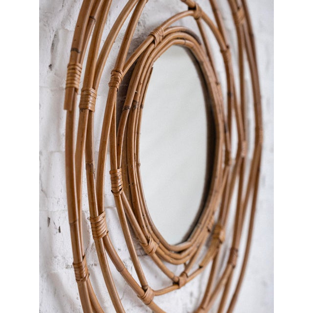 Mid century Italian circular wall mirror with a web-like rattan frame. Sourced in Italy.