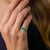 This striking Retro English ring showcases three beautifully matched rectangular cushion cut emeralds totaling...