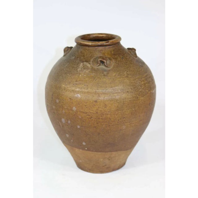 An extraordinary antiquity for the Connoisseur. The beautifully aged gradated brown earthen wine vessel from Thailand, has...