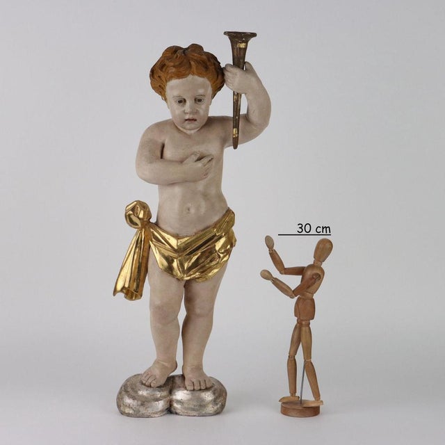 Putto torch holder in carved, lacquered and gilded wood. This piece is attributed to the mentioned designer/maker. It has...