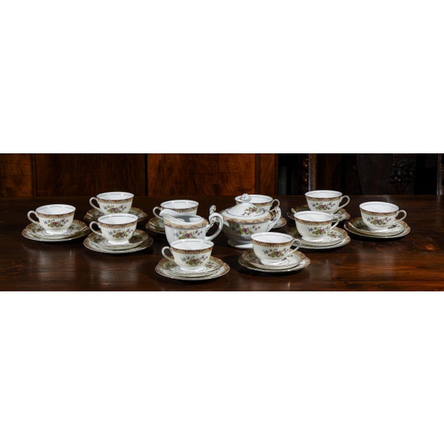 Tea set composed of 10 cups, 10 saucers, 10 saucers, a creamer and a sugar bowl made of porcelain decorated with flowers...