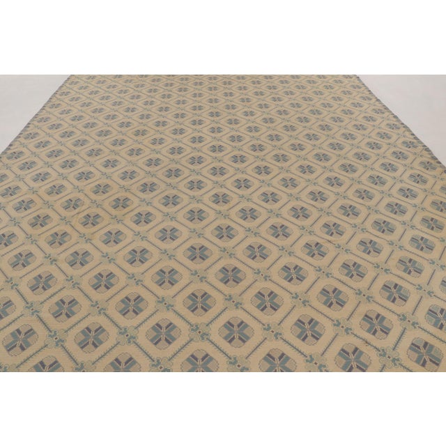 Hand-embroidered in wool and originating circa 1950-1960, this 12x16 vintage Portuguese needlepoint rug is an exceptional...