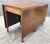A beautifully proportioned antique mahogany drop-leaf dining table featuring exceptionally rich grain, slender tapered...