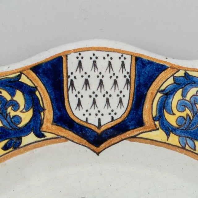 A late 19th century French Malicorne faience pate, hand painted with Breton man and child in traditional costume and...