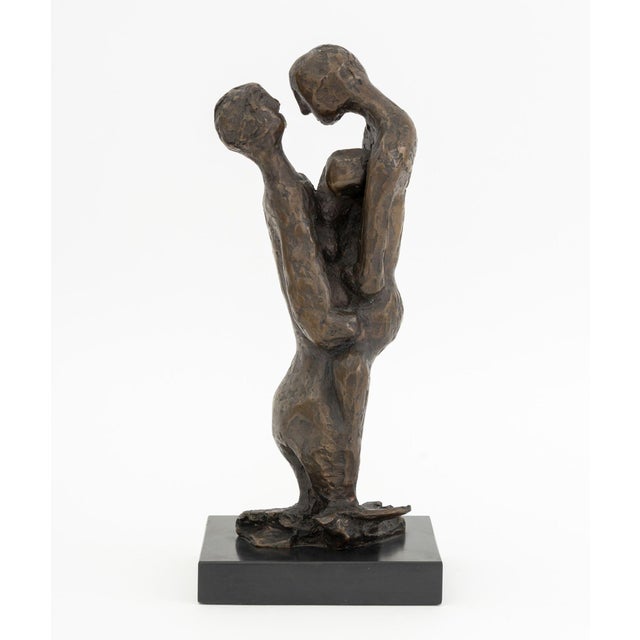 Family Embrace Bronze Sculpture, illegible signature and numbered edition "6/18" near base, mounted atop a black marble...
