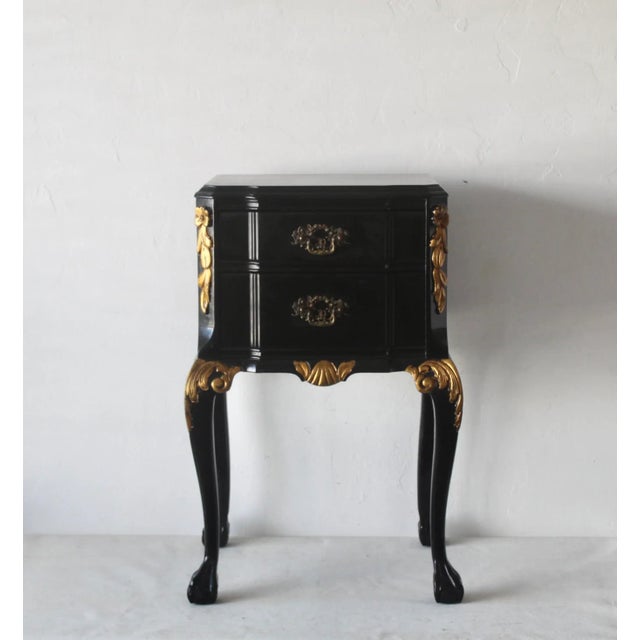 A handsome Louis XV style black lacquered nightstand, end or side table, reminiscent of La Maison London. Decorative gold...