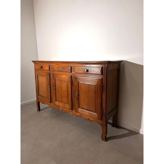 An elegant oak sideboard combining generous storage with classic country-style detailing. Its warm brown finish highlights...