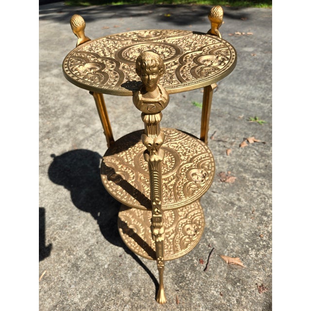 Offering an ornate, heavy metal 3 tier stand. The stand has 3 victorian styled legs, topped with a female bust. Each tier...