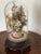 Beautiful antique sea shell flowers bouquet with yellow immortella dry flowers in a glass dome on wood carved stand.