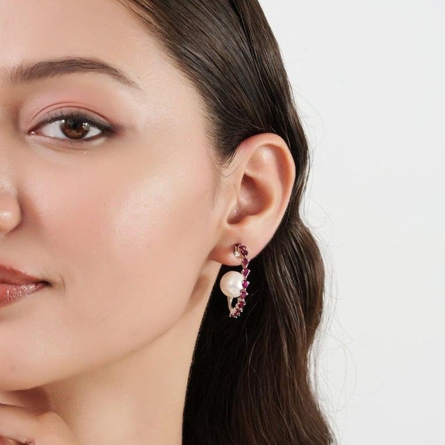 Crafted in 925 sterling silver, these elegant earrings feature pear and round-cut rubies totaling 3.75 carats, beautifully...