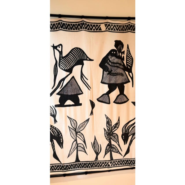 Striking vintage African wall tapestry featuring bold black hand-printed or woven figures on natural cotton. The graphic...