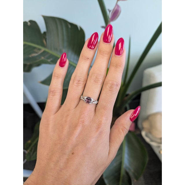 A 1.12-carat natural purple spinel glows in a rich grape-purple at the centre of this solid 14K white gold ring, framed by...