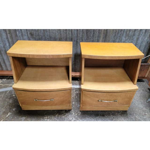 A pair of Mid-Century Modern nightstands with large storage drawer and shelf. Original finish and hardware. Solid oak...