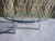 Coffee table featuring a 2 cm thick clear glass top mounted on a chromed steel tube frame. All rubber bumpers are present....