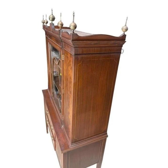 Elegant antique mahogany display cabinet in the Hepplewhite style, featuring beautiful satinwood inlay, tapered legs, and...