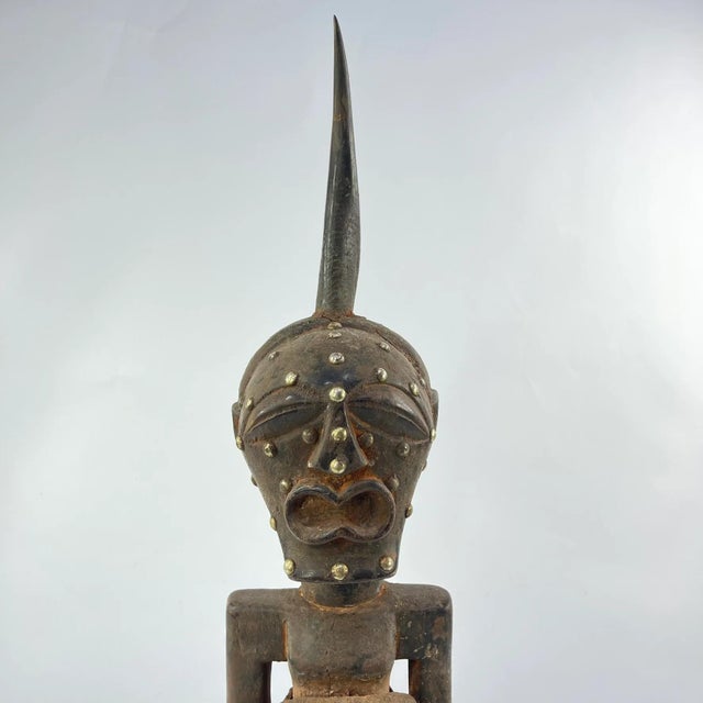 In larger Nkishi representations, the figure serves as a guardian for the entire community, acting as a mediator between...