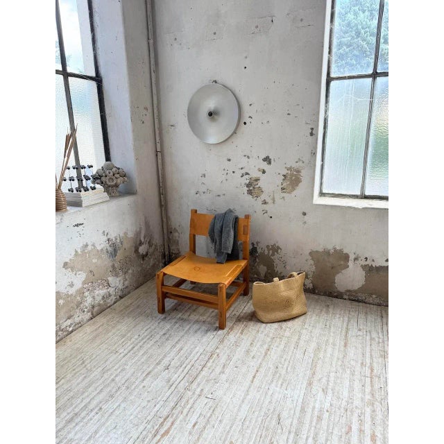 Antique armchair by Maison Regain, made of solid elm and cognac leather from the 1970s. We love the beautiful woodwork and...