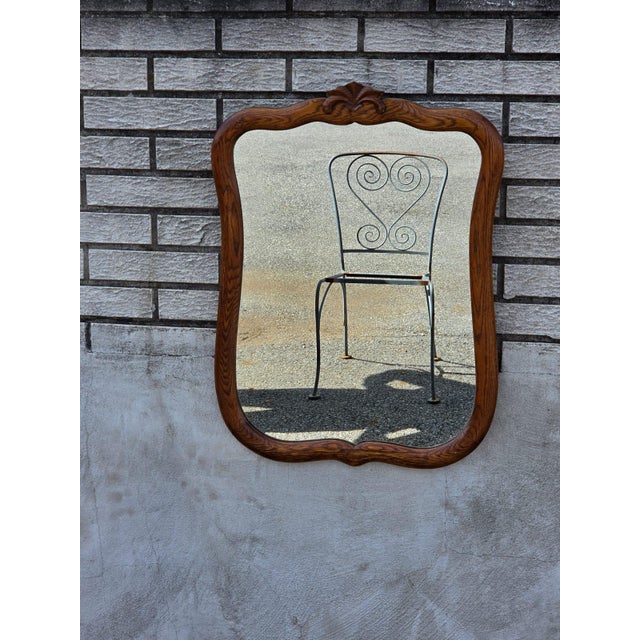 The 1920 oak bathroom mirror is an antique piece with a rectangular shape and a brown color. It features a mirrored frame...