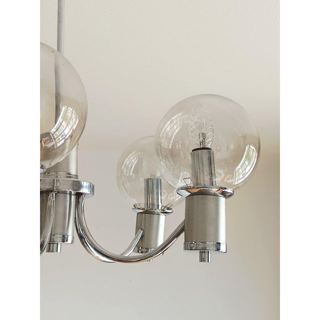 Five-arm space age style chandelier in chrome and brushed aluminum. Each arm is topped with a round smoked glass globe....