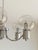 Five-arm space age style chandelier in chrome and brushed aluminum. Each arm is topped with a round smoked glass globe....