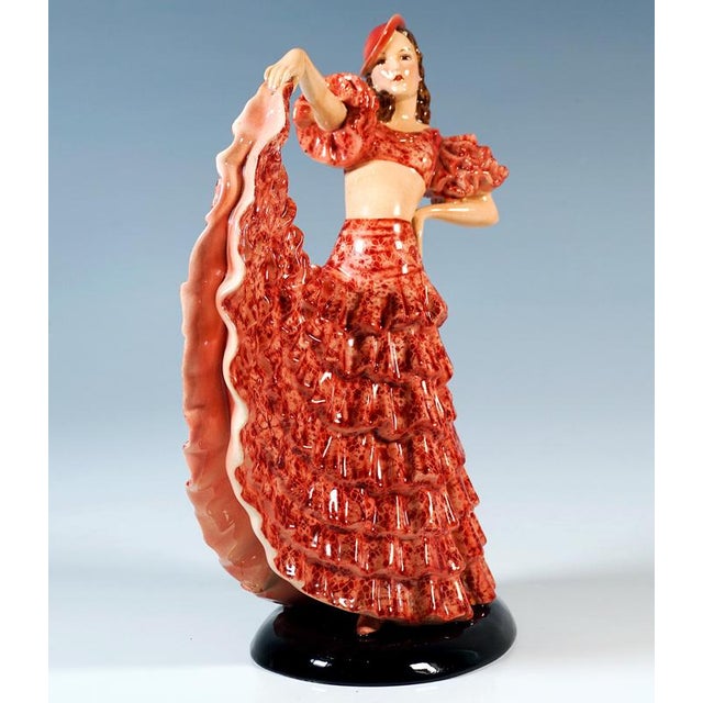 Finest viennese art ceramic from the 1930s: standing dancer in a long ruffled skirt with red lace decoration, which she...