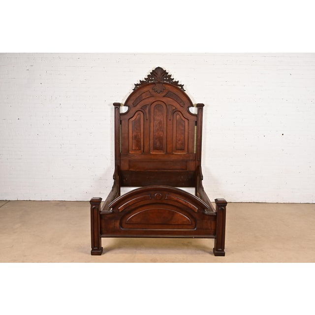 A gorgeous monumental antique Eastlake Victorian carved walnut and burl wood full size bed frame In the manner of Herter...