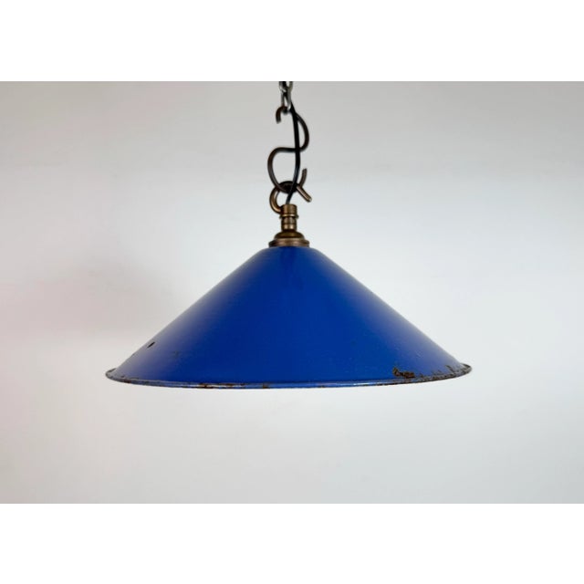 Industrial blue enamel factory pendant light made in United Kingdom during the 1950s. White enamel inside the shade. Brass...
