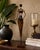 This vintage African-inspired handcrafted metal sculpture depicts a graceful female figure carrying a traditional vessel,...