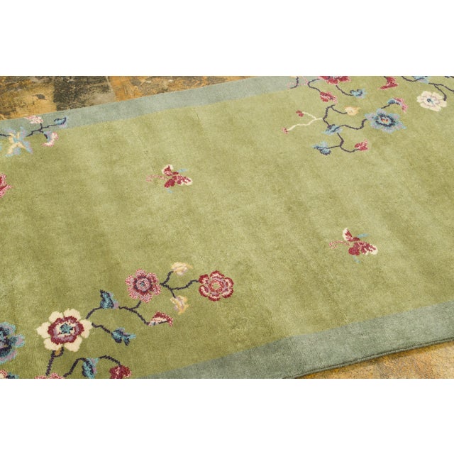 Hand-knotted in wool, this 3x5 contemporary Chinese Deco rug showcases an olive-green center encircled by a soft sage...