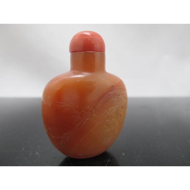 Chinese Qing Dynasty era chalcedony/agate snuff bottle in coral tone with stopper and intact spoon. Carved flowers and...