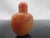 Chinese Qing Dynasty era chalcedony/agate snuff bottle in coral tone with stopper and intact spoon. Carved flowers and...