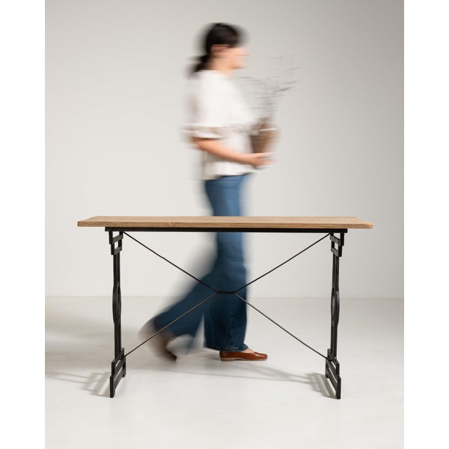A classic French café table combining a cast iron base with a wooden top, reflecting the enduring design of Parisian...
