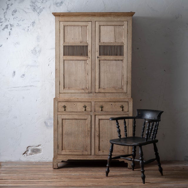 Bleached Welsh oak cwpwrdd bara a caws (bread and cheese cupboard), circa 1820, of characteristic form with twin doors...