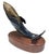 Elegant bronze whale sculpture mounted on a polished oak wooden base. The whale rises gracefully, its golden-toned back...