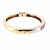 Vintage hinged bangle bracelet carfted in 14K yellow and white gold, featuring a sequence of round-cut red rubies and...