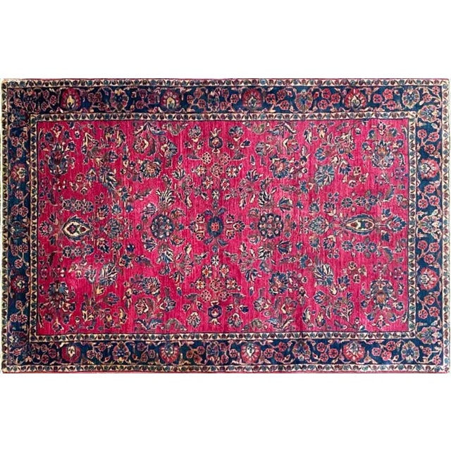 Foundation: Cotton foundation with fine wool pile Colors: Rich raspberry-red field, deep navy-blue border, ivory, soft...