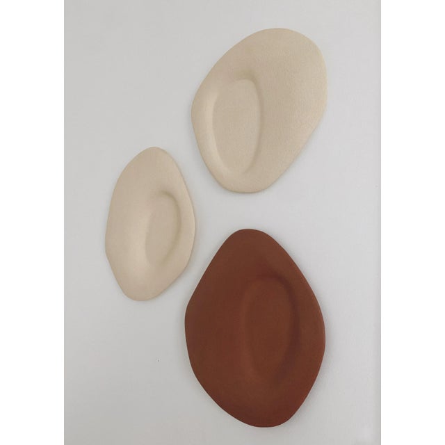 Set of 3 particules elémentaires wall sculptures by léontine furcy. Unique pieces. Materials: rough chamotte white...