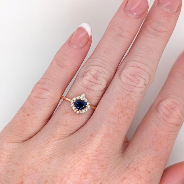 Stunning is an understatement for this ring! The all natural diamond halo and accents perfectly emphasize the vivid blue...