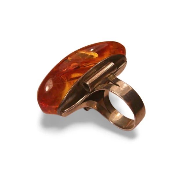 This Art Deco ring band is crafted in 925 sterling silver and features a huge natural Baltic amber centerpiece. The amber...