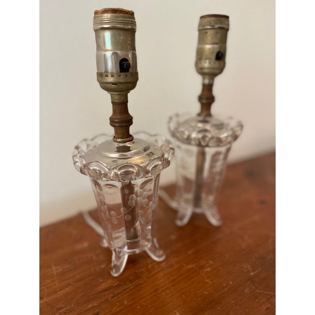 Sweet pair of petite table lamps made from antiqued glass. Details include etched florals and scalloped top. Pair these...
